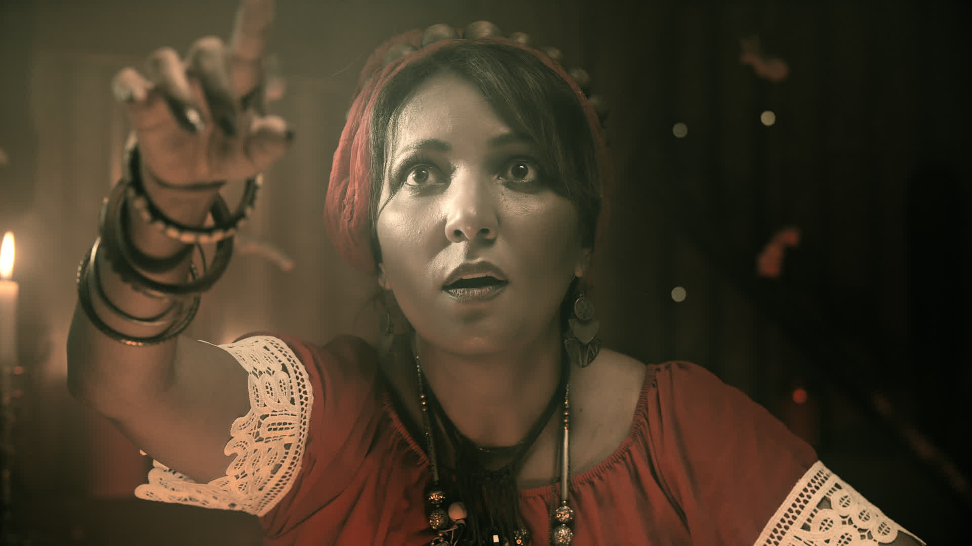 Une femme portant une tenue rouge avec des ornements blancs et des bracelets noirs, tenant une cigarette sous une lumière ...