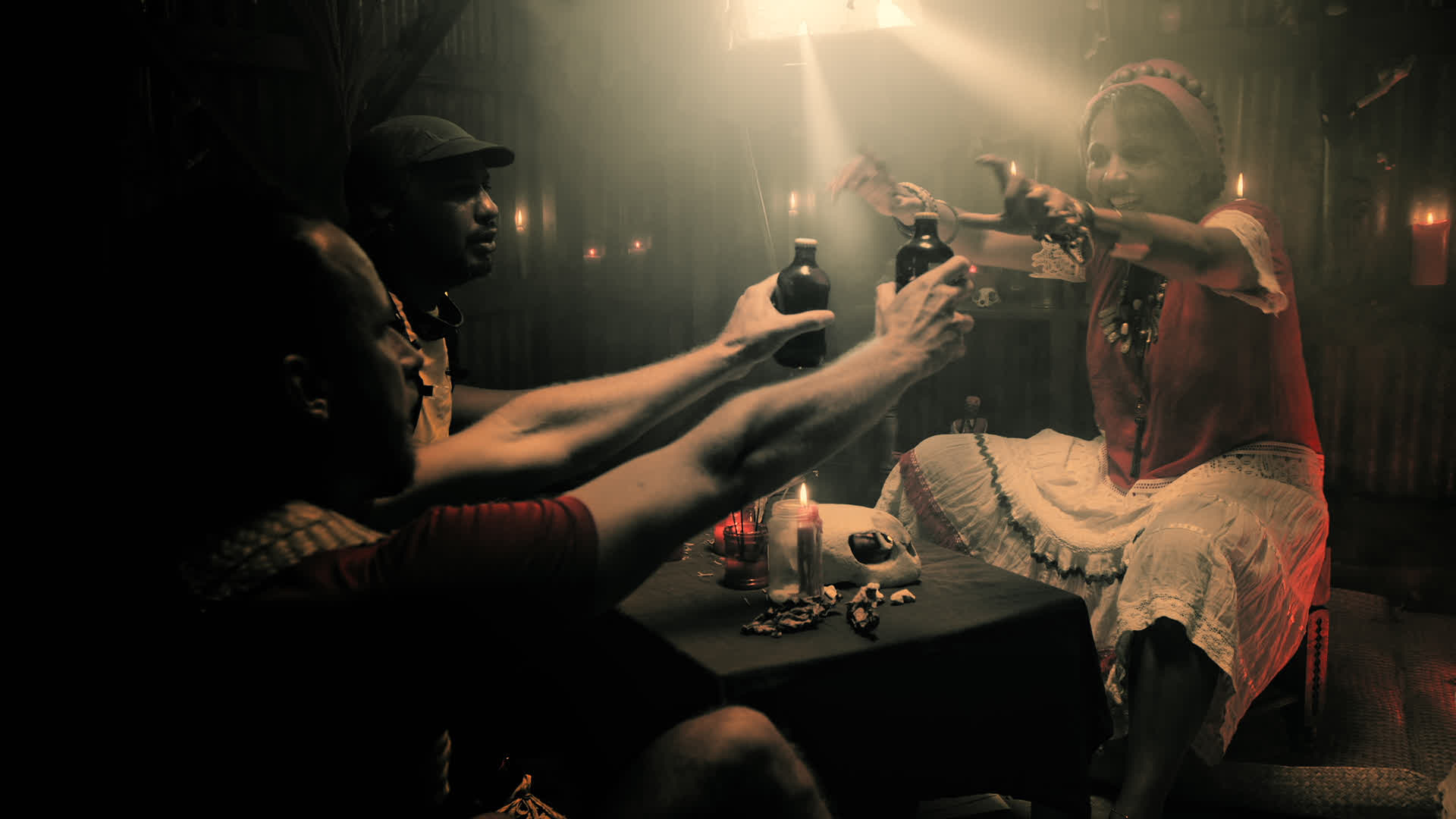 Femme vêtue de robe rouge et blanche dans une pièce sombre avec des bougies allumées - ambiance mystérieuse