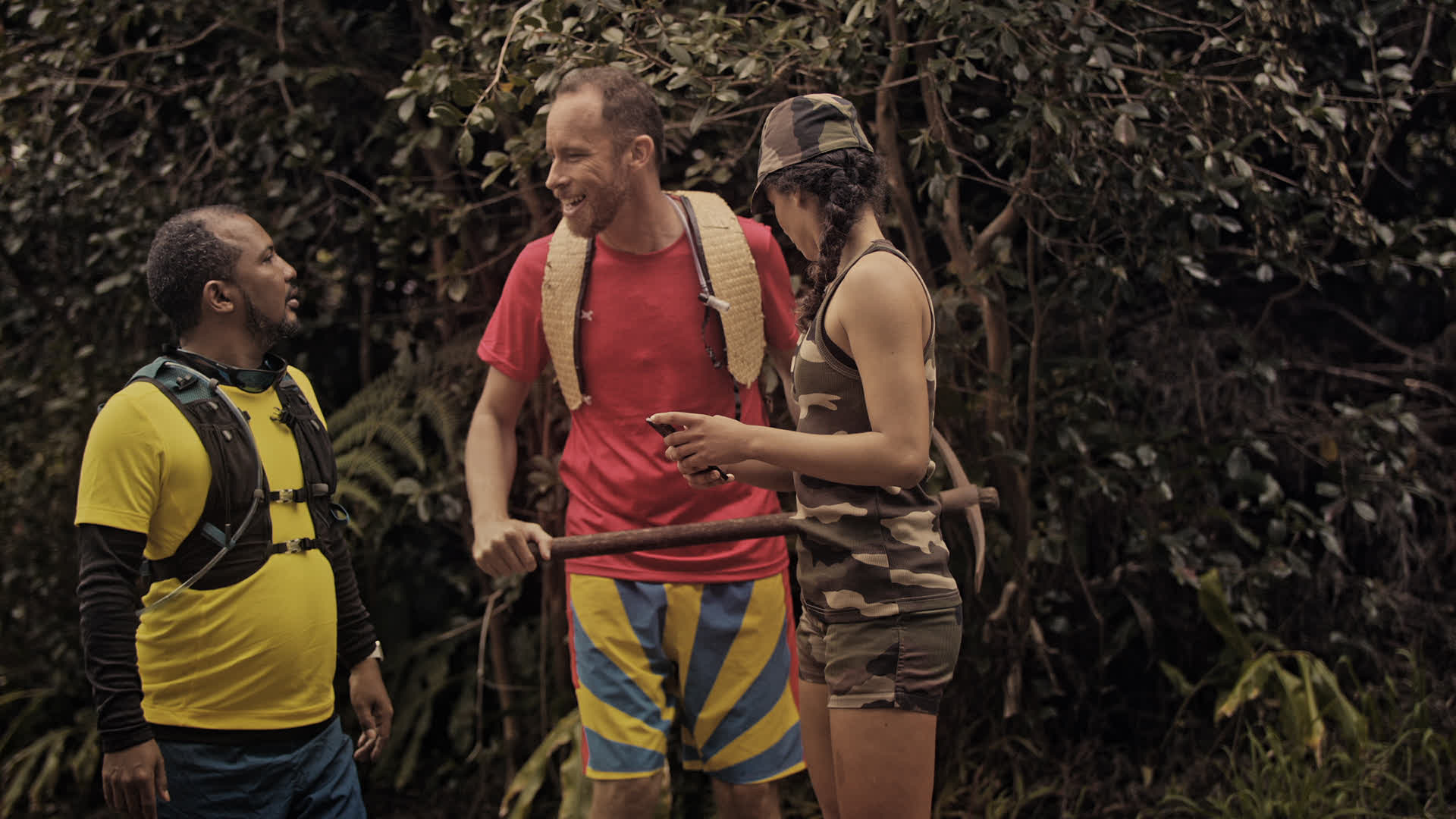 Trio discutant dans une forêt dense, vêtements camo et survie - Production audiovisuelle