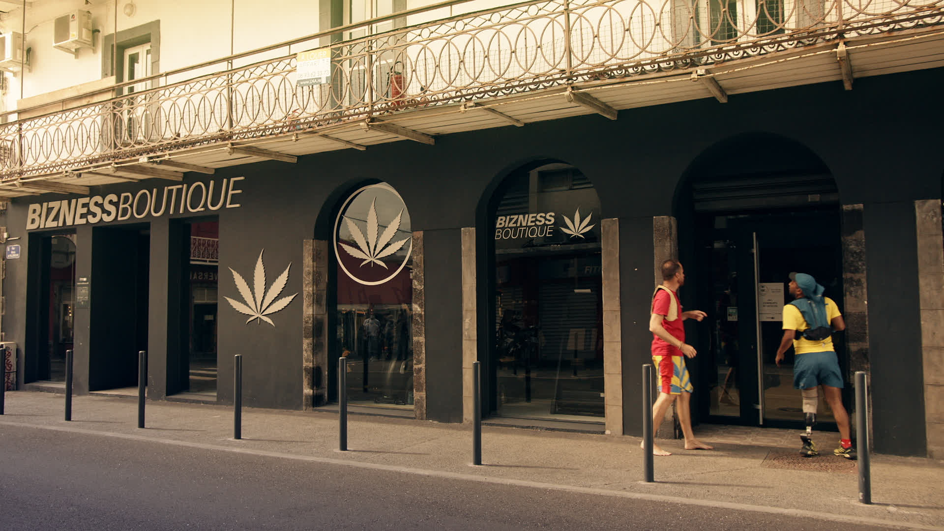 Facade de la boutique BIZNESS BOUTIQUE avec logo cannabis, ambiance urbaine et architecture moderne.